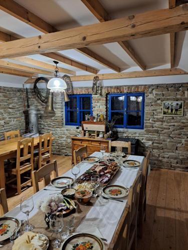 a dining room with a long table with plates of food at Casa Klein- întreaga locație in Meşendorf