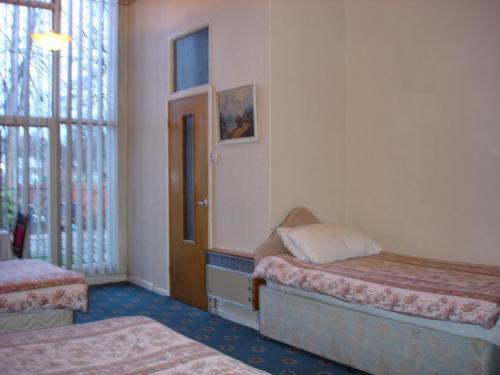 Un dormitorio con dos camas y una ventana. en Victoria Park Hotel, en Mánchester