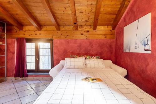 ein Schlafzimmer mit einem großen Bett in einer roten Wand in der Unterkunft Dimora Gilles Bard in Bard