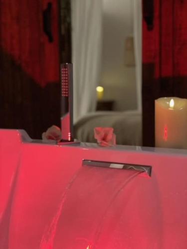 a red table with a remote control and a candle at BALI DREAM, pour une escapade inoubliable! in Grenoble