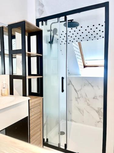 une salle de bain avec une douche avec une porte vitrée dans l'établissement Près de l aéroport Orly Parking gratuit, à Villeneuve-le-Roi