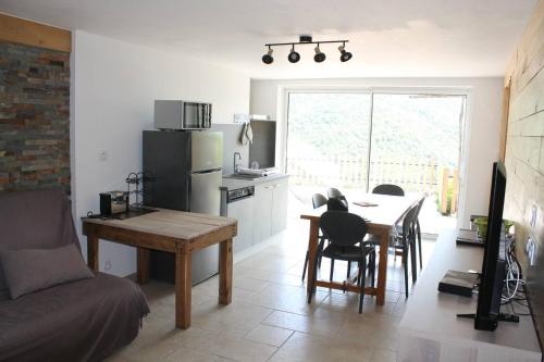- une cuisine et une salle à manger avec une table et un canapé dans l'établissement Location Les Aydons, à Sainte-Marguerite-Lafigère