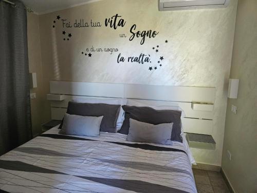 a bedroom with a bed with words on the wall at B&B Ferro di Cavallo in Tivoli