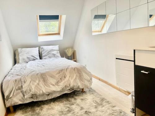 een slaapkamer met een bed in een witte kamer bij Près de l aéroport Orly Parking gratuit in Villeneuve-le-Roi