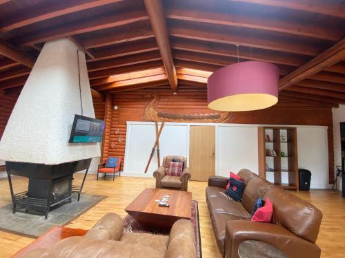 a living room with a couch and a fireplace at Kaoglen-GrandSuite-Hot Tub-Pitlochry-Dunkeld-Pet Friendly in Balnald