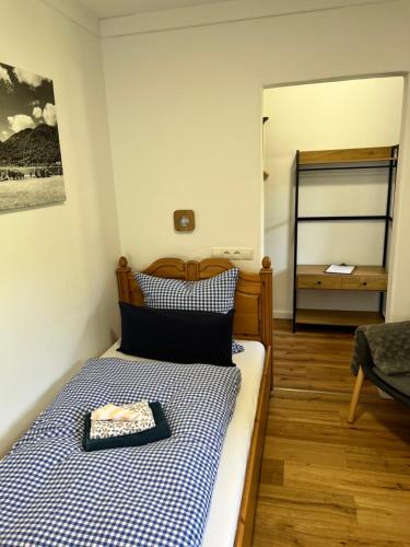 a bedroom with a bed with a blue and white checkered blanket at REIT IM WINKL - ValleyViewInn in Reit im Winkl