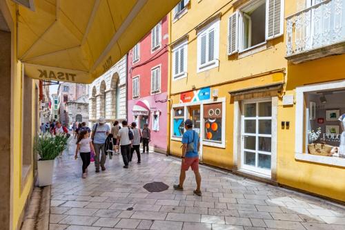 a group of people walking down a street at Zaratino in Zadar