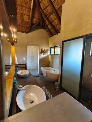 a large bathroom with two sinks and a tub and a sink at Elandsfontein 21, Mabalingwe in Mabula