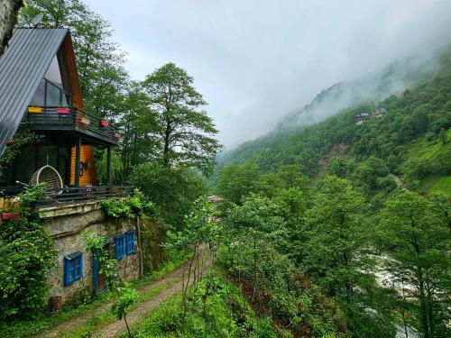 a house on the side of a hill with a mountain at Zayna bungalov in Çamlıhemşin