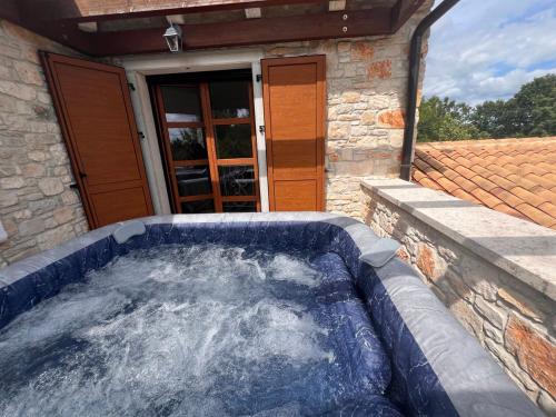 a hot tub in front of a house at Villa Valeria in Divšići