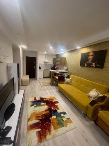 a living room with a yellow couch and a kitchen at Lucas investment L3 -104 in Creţuleasca
