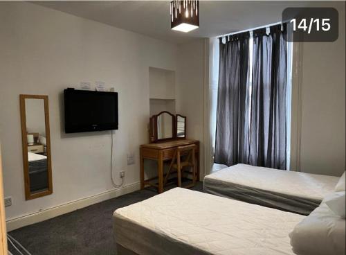 a hotel room with two beds and a television at Easy sleep in Dundee