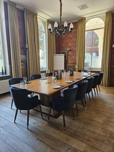 a conference room with a large wooden table and chairs at Hotel De Villa in Dongen