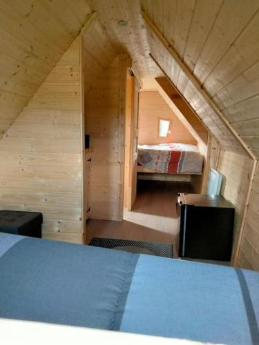 a small room with a bed in a wooden house at Cabane - La Forest in Épuisay