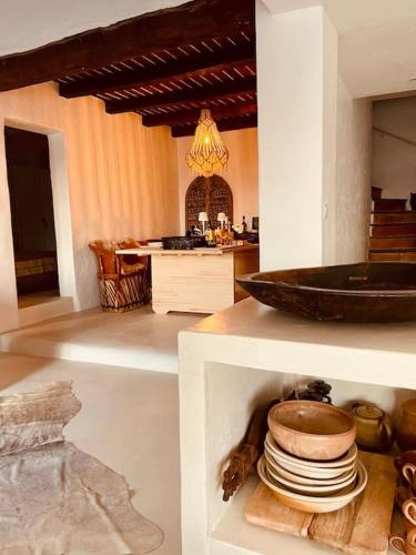 une cuisine avec une pile d'assiettes sur une étagère dans l'établissement Mas de charme 133m2 piscine chauffée vue mer panoramique, à Cavalaire-sur-Mer