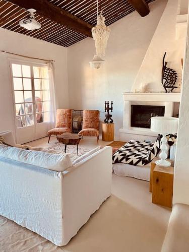 un salon avec un canapé et une cheminée dans l'établissement Mas de charme 133m2 piscine chauffée vue mer panoramique, à Cavalaire-sur-Mer