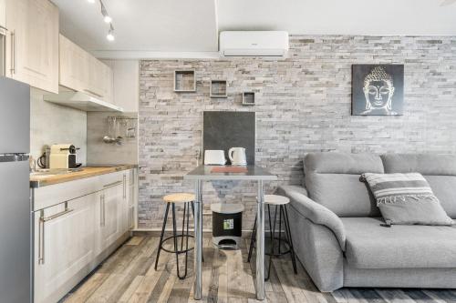 una cucina e un soggiorno con un divano e un tavolo di WELCS ESTUDIO 156 PDA en el centro a Platja  d'Aro