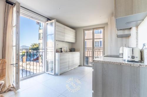 une cuisine avec une grande porte vitrée donnant sur un balcon dans l'établissement A&A by Time Off Collection, à Saint-Tropez
