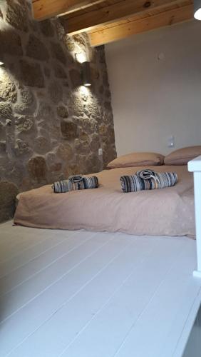 a bed in a room with some pillows on it at Nisyros Nest in Nikiá