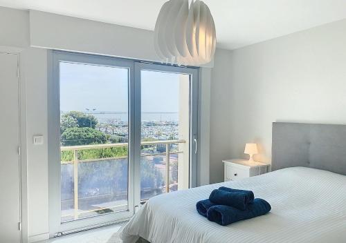 une chambre avec un lit et une grande fenêtre dans l'établissement Horizon bleu vue mer dernier étage clim, à Saint-Laurent-du-Var