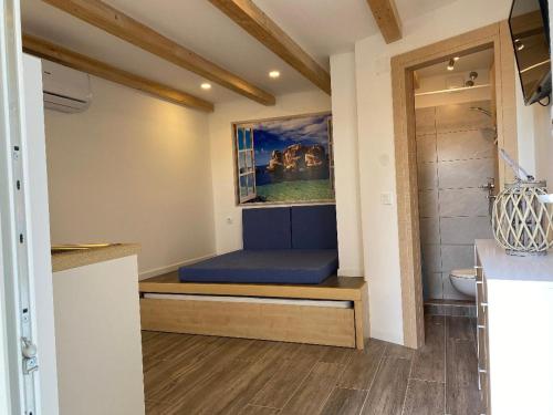 Mały pokój z niebieskim łóżkiem w łazience w obiekcie Studio Mirjana w mieście Prvić Luka