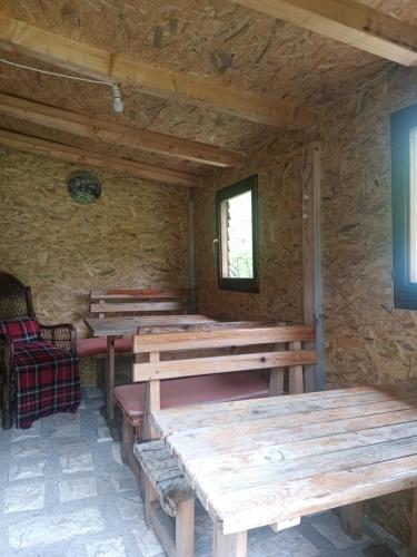 Zimmer mit Holztischen in einer Steinwand in der Unterkunft Eko Katun Kolijevka in Berane