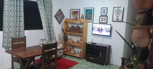 a room with a table and a shelf with shoes at Apartamento Praia do Janga Paulista Pe in Paulista