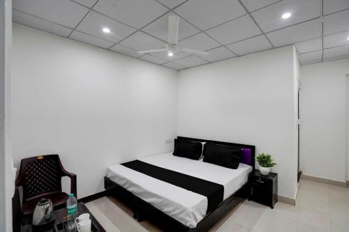 een slaapkamer met een bed en een stoel bij SPOT ON Hotel Blu Moon in Noida