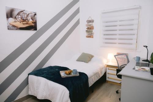 - une chambre avec un lit et un plateau de nourriture dans l'établissement Piso compartido Delyrent, SFJ, à Jaén