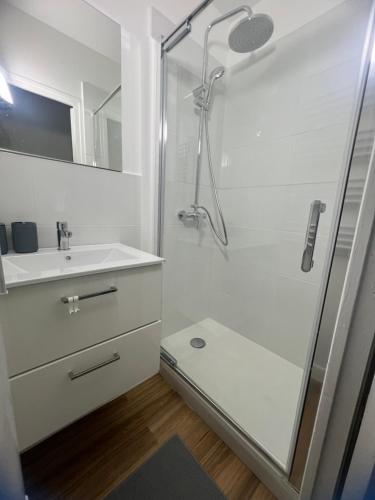 a white bathroom with a shower and a sink at Modern Renovated Apartment -15 min Orly airport in Viry-Châtillon