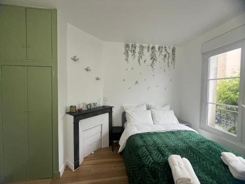 a bedroom with a bed with a green blanket and a window at Modern Renovated Apartment -15 min Orly airport in Viry-Châtillon