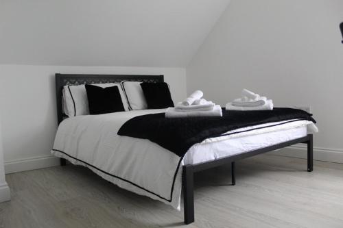 a bedroom with a large bed with black and white pillows at 1 Bedroom Flat in Bedford in Bedford