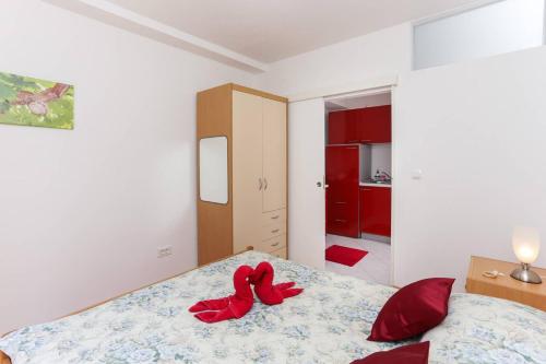 a bedroom with a bed with red shoes on it at Charming Apartment in Dubrovnik | 40 m² | Parking Included in Dubrovnik
