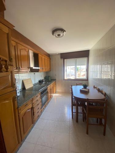 a kitchen with wooden cabinets and a table with chairs at Avenida 37 in Caldas de Reis