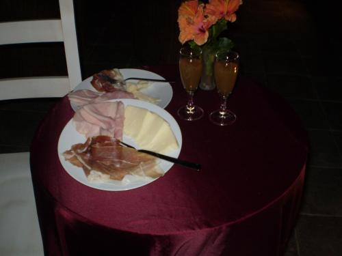 a table with a plate of food and two wine glasses at Hotel Sa Cralla Villasimius in Villasimius