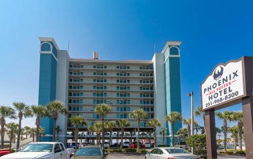 un hôtel avec des voitures garées dans un parking dans l'établissement Phoenix All Suites Hotel, à Gulf Shores