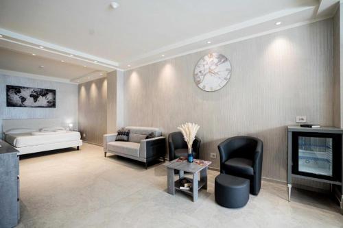 a living room with a couch and a bed and a clock at Catania Sea Palace Hotel in Catania