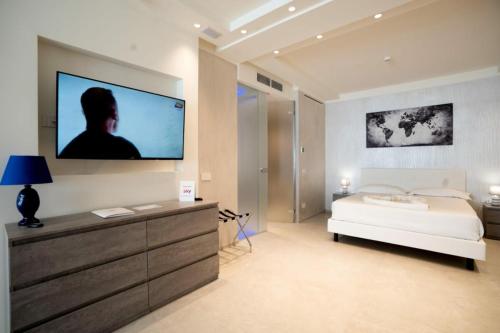 a bedroom with a bed and a tv on a wall at Catania Sea Palace Hotel in Catania
