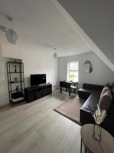 a living room with a couch and a piano at 1 Bedroom Flat in Bedford in Bedford