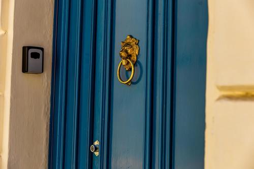 a blue door with a gold door knocker on it at Characterful ground floor townhouse in Tal-Għoqod