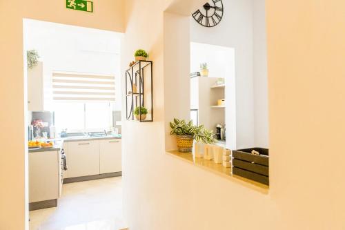 a kitchen with white cabinets and a clock on the wall at Characterful ground floor townhouse in Tal-Għoqod