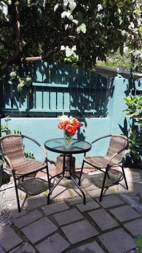 una mesa con dos sillas y un jarrón de flores. en Madera Hotel, en Tiflis