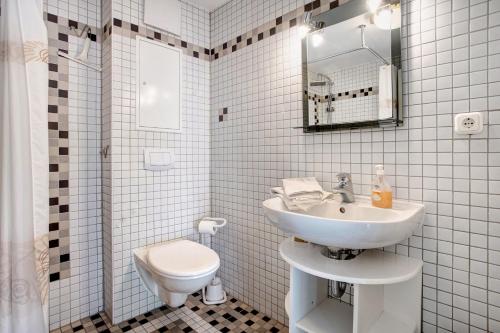 Un baño blanco con lavabo e inodoro. en Caeser - Ferienwohnungen Zinnowitz, en Zinnowitz