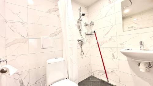 a white bathroom with a toilet and a sink at Kastanimaja Apartments in Tartu