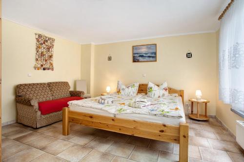 Un dormitorio con una cama grande y un sofá. en Caeser - Ferienwohnungen Zinnowitz, en Zinnowitz