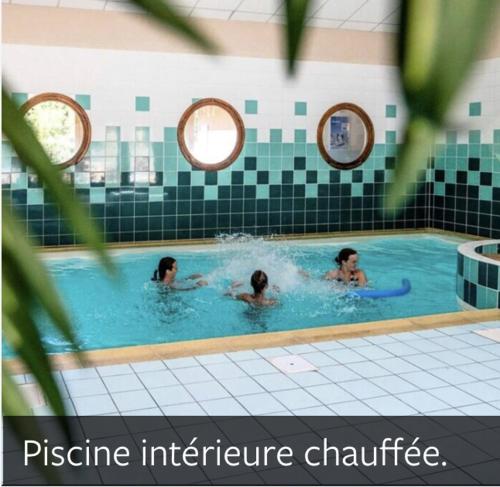 duas pessoas a nadar numa piscina em Samoëns Appartement T3 RDC 6 personnes, piscines, sauna, salle de détente sports em Samoëns