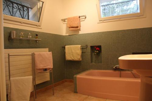 La salle de bains est pourvue d'une baignoire, d'un lavabo et de serviettes. dans l'établissement appartement 100 m 2 situé dans pinède et villa familiale, à Ensuès-la-Redonne