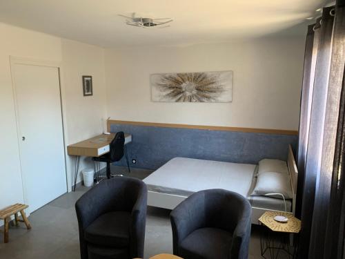 pokój z łóżkiem, dwoma krzesłami i biurkiem w obiekcie Grand studio très agréable avec bar, cuisine et terrasse w Cagnes-sur-Mer