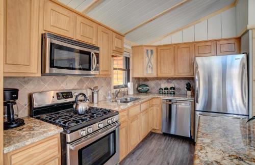 a kitchen with wooden cabinets and stainless steel appliances at Warrick Cabin in Creede