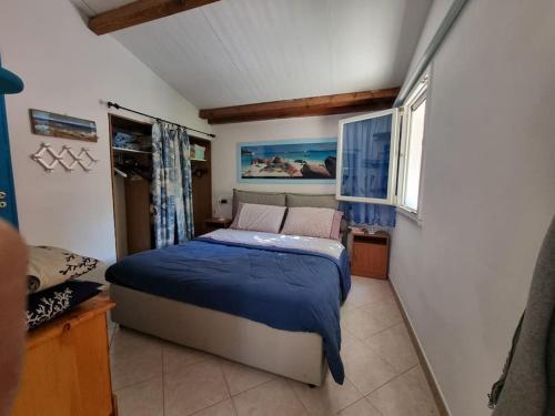 a bedroom with a bed with a blue blanket at Patty's Cottage with private PARKING in Lerici